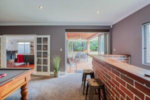 a living room with a pool table and a brick wall at Rivervale Retreat - Spacious Family Living in Perth