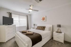 Un dormitorio blanco con una cama y un televisor de pantalla plana. en Rivervale Retreat - Spacious Family Living, en Perth 30 fotos más