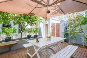 a patio with a white table and an umbrella at 'Karrinyup Villa' Lush Indoor-Outdoor Living in Perth
