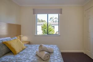 パースにあるBelmont Comfort - Central and Light-filled Stayの大きな窓のあるベッドのある寝室