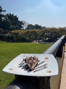 Santa Lucía Milpas Altas的住宿－HOTEL Y RESTAURANTE HACIENDA LOS VOLCANES，铁轨上盘子上的一块巧克力蛋糕