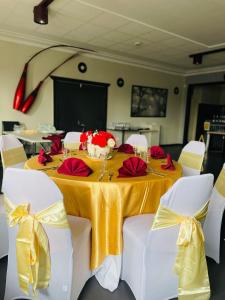 una mesa con un mantel amarillo y flores rojas. en Club Hotel, en Glen Innes