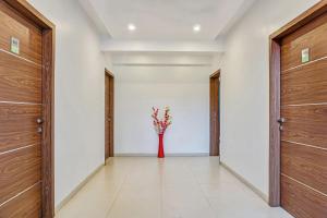 un corridoio con due porte e un vaso con dei fiori di Super Townhouse 749 The Upper Room Near Pune Airport a Lohogaon