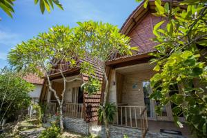 a wooden house with trees in front of it at Desa Sweet Cottages in Nusa Lembongan