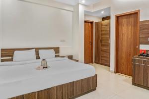 a bedroom with a large white bed and wooden cabinets at Super Townhouse 749 The Upper Room Near Pune Airport in Lohogaon