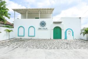 um edifício branco com uma porta verde em Ubu Villa Gito Gati - 4 Bedrooms Villa near Yogyakarta City Center em Ngaglik