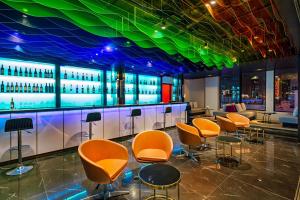 a bar with orange chairs and a green ceiling at Satya Danang Hotel in Danang