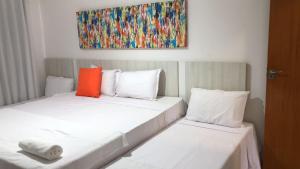 two beds in a room with a painting on the wall at Arraial d Ajuda - Casa Oásis - Residencial Monte das Oliveiras in Porto Seguro +46 photos