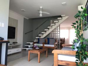 a living room with a spiral staircase in a house at Arraial d Ajuda - Casa Oásis - Residencial Monte das Oliveiras in Porto Seguro