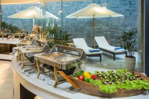 a buffet line with fruits and vegetables on a counter at Satya Da Nang Centre Hotel - Han Market, Pink Chicken Church View in Danang