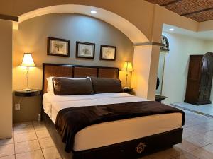 Jalostotitlán的住宿－Hotel & Eventos Xalos，一间卧室配有一张大床,上面有拱门