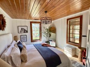 a bedroom with a bed and a wooden ceiling at Stone House by Casa Oso, hot tub, 43 private acres with hiking trails in Mariposa