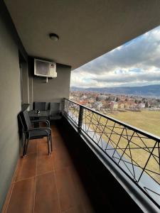 uma varanda com uma mesa e cadeiras e uma vista em Kanna Apartments - Bulevar - Free Parking em Sarajevo