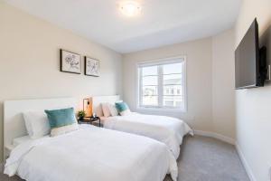 - 2 lits blancs dans une chambre avec fenêtre dans l'établissement Modern 3BR, 15min to Falls/Attractions W/ King Bed, à Thorold