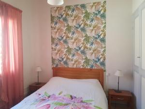 um quarto com uma cama com papel de parede floral em Appartement Banyuls-sur-Mer, 3 pièces, 4 personnes - FR-1-309-380 em Banyuls-sur-Mer