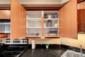 a kitchen with wooden cabinets with dishes on shelves at Royal Oasis Suite in Las Vegas