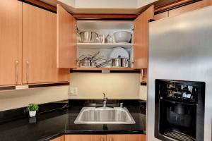 a kitchen with a sink and a microwave at Royal Oasis Suite at Platinum Hotel-Strip Views in Las Vegas