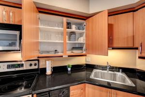 a kitchen with wooden cabinets and a sink at Royal Oasis Suite in Las Vegas