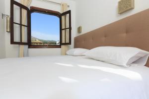 シェフシャウエンにあるリヤド ザイトウナ シャウエンの白いベッドと窓のある寝室