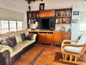 uma sala de estar com um sofá e uma televisão em Finca el Paraíso em Los Santos