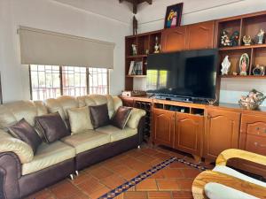 uma sala de estar com um sofá e uma televisão de ecrã plano em Finca el Paraíso em Los Santos