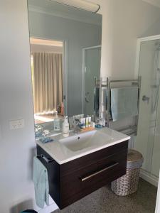 a bathroom with a sink and a large mirror at Kaimai Range Country Getaway in Katikati