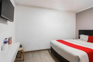 1 dormitorio con 1 cama con manta roja y blanca en Super OYO Cideng Timur Residence Near MONAS en Yakarta