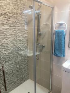 La salle de bains est pourvue d'une douche avec une porte en verre. dans l'établissement Modern SeaFront 3bedrooms Apartment, à San Pawl il-Baħar