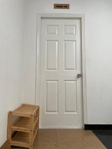 Your House في مدينة هوشي منه: باب أبيض مع علامة فوقه بجوار كرسي خشبي