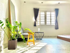 a room with a yellow chair and a window at Your House in Ho Chi Minh City