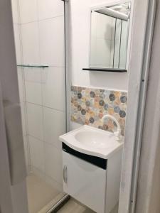 ein Badezimmer mit Waschbecken, Spiegel und Dusche in der Unterkunft Casa no Mar de Junqueira in Mangaratiba