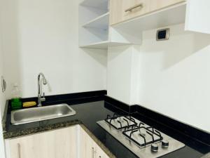 a kitchen with a stove and a sink at APARTA SUITES GRANADA LOF 3 in Cali