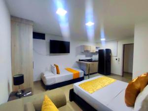 a hotel room with two beds and a couch at APARTA SUITES GRANADA LOF 3 in Cali