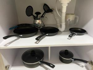 three pots and pans on a shelf in a kitchen at APARTA SUITES GRANADA LOF 3 in Cali