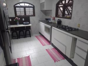 a kitchen with white appliances and pink and white tiles at LINDA CASA DE PRAIA EM PIRATININGA in Niterói