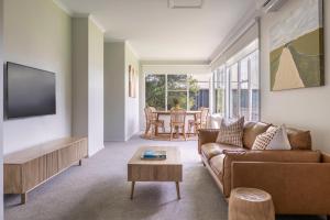 uma sala de estar com um sofá e uma mesa em Red Rocks Golf & Accommodation - Phillip Island em Cowes