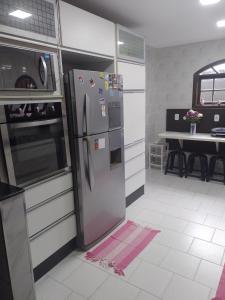 a kitchen with a stainless steel refrigerator and a table at LINDA CASA DE PRAIA EM PIRATININGA in Niterói