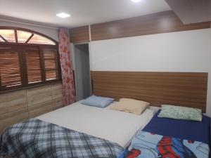 a bedroom with a large bed and a window at LINDA CASA DE PRAIA EM PIRATININGA in Niterói