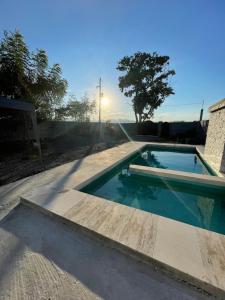 una piscina con puesta de sol en el fondo en Casa de las estrellas, en Valles