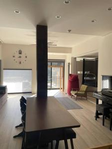 a living room with a table and a piano at 1日1組限定　和洋折衷 EDOYA in Chiba
