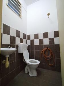 y baño con aseo y lavamanos. en Homestay Rayyan PD, en Port Dickson