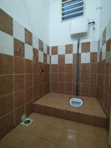 ein Bad mit WC in einem gefliesten Zimmer in der Unterkunft Homestay Rayyan PD in Port Dickson