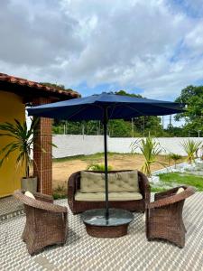 ein blauer Regenschirm auf einem Tisch mit einem Sofa und Stühlen in der Unterkunft Espaço Prime SLZ in São Luís