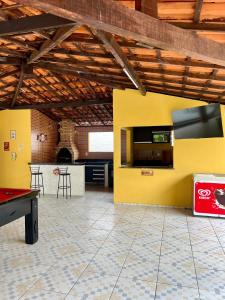 Habitación con mesa de ping pong y pared amarilla. en Espaço Prime SLZ en São Luís