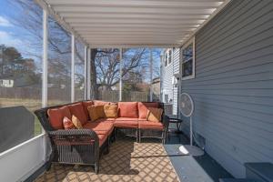 a screened in porch with a couch on a patio at Stylish Haven 11 Minutes from the Richmond Airport in Richmond