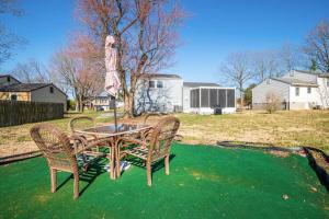 a table with three chairs and a umbrella in a yard at Stylish Haven 11 Minutes from the Richmond Airport in Richmond