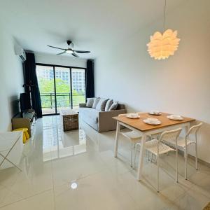 uma sala de estar com uma mesa e um sofá em Forest city Sea view homestay em Gelang Patah