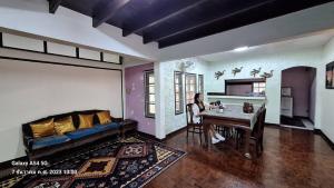 a woman sitting at a table in a living room at Huaykhakhaeng Country Home Resort in Ban Rai