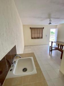 een witte wastafel in een kamer met een tafel bij Sol y Luna Hospedaje in Valladolid