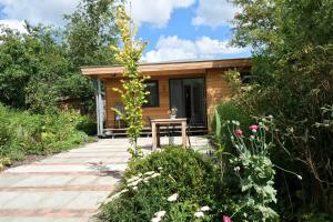 Cabaña de madera pequeña con mesa en el jardín en "Heleen" 6 pers, Lauwersmeer waterfront, full equipped and modern, en Anjum